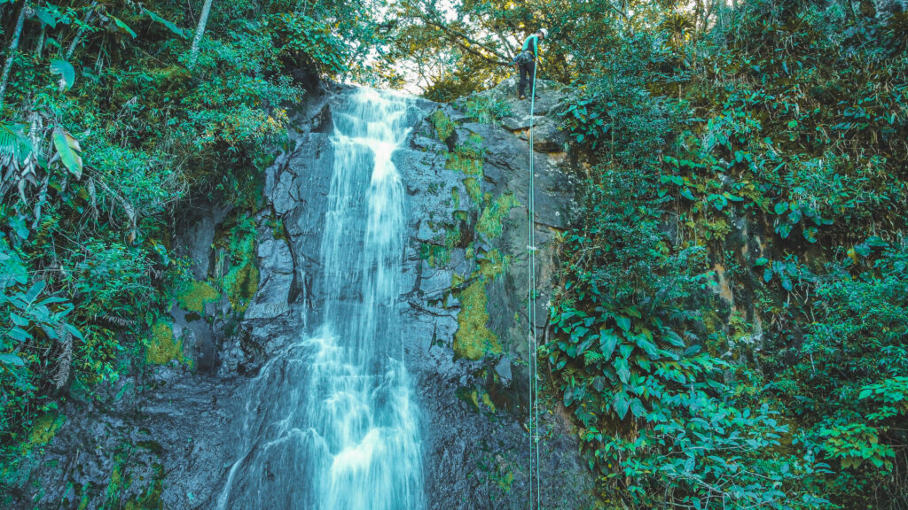 Cachoeira com uma pessoa descendo de rapel ao lado em Praia Grande - Santa Catarina